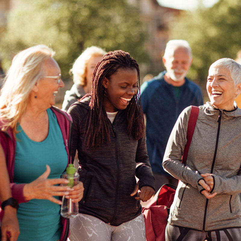 Smiling group of people walking together outdoors.